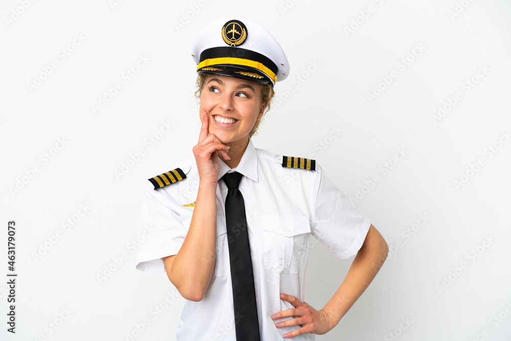 Airplane blonde woman pilot isolated on white background thinking an idea while looking up Airplane blonde woman pilot isolated on white background thinking an idea while looking up