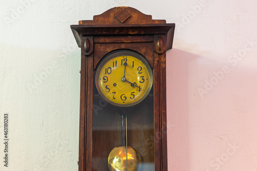 Old large wooden clock with a pendulum.