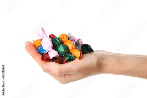 Woman holding heap of candies in colorful wrappers isolated on white, closeup