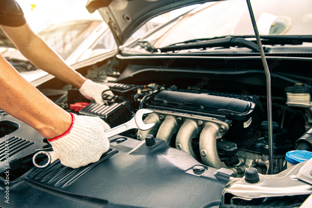 Car care maintenance and servicing, Close-up hand technician auto mechanic using the wrench to repairing change spare part car engine problem. Concepts of check and during periodic inspection service. Car care maintenance and servicing, Close-up hand technician auto mechanic using the wrench to repairing change spare part car engine problem. Concepts of check and during periodic inspection service.