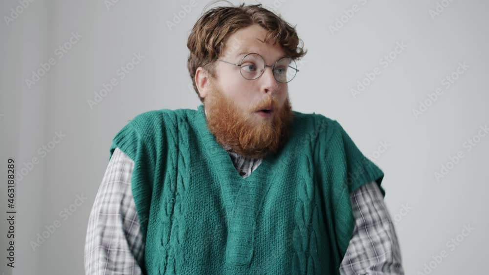 Slow motion portrait of chubby young man making funny grimaces and looking at camera against white background. Crazy people and behavior concept. Slow motion portrait of chubby young man making funny grimaces and looking at camera against white background. Crazy people and behavior concept.