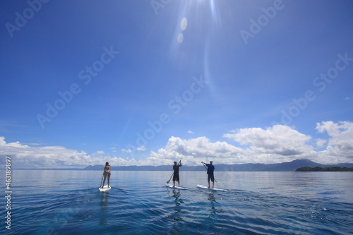 people paddling sup standup paddle boards in calm blue waters. Philippines