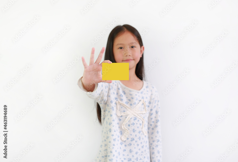 Asian little girl child showing blank yellow card over white background. Focus at card in hand Asian little girl child showing blank yellow card over white background. Focus at card in hand