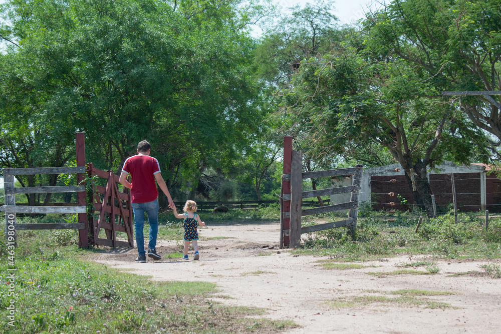 Fototapeta premium Father and child walking to the room with their backs turned