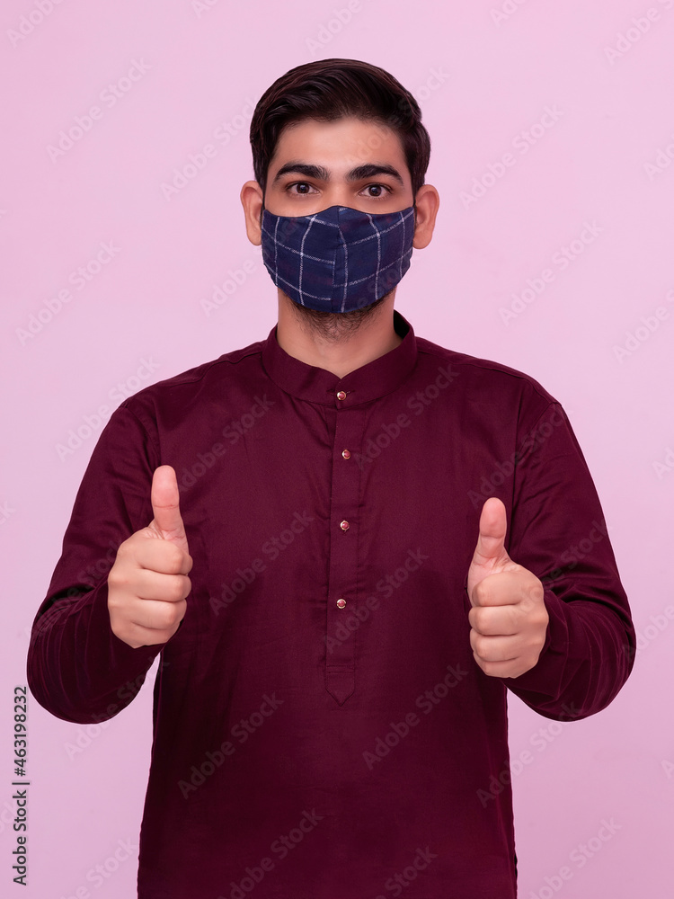 Indian adult boy wearing mask with thumbs up gesture. Indian adult boy wearing mask with thumbs up gesture.