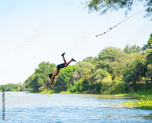 Man jumping into the water of a riber in the middle of the jungle 3 photo