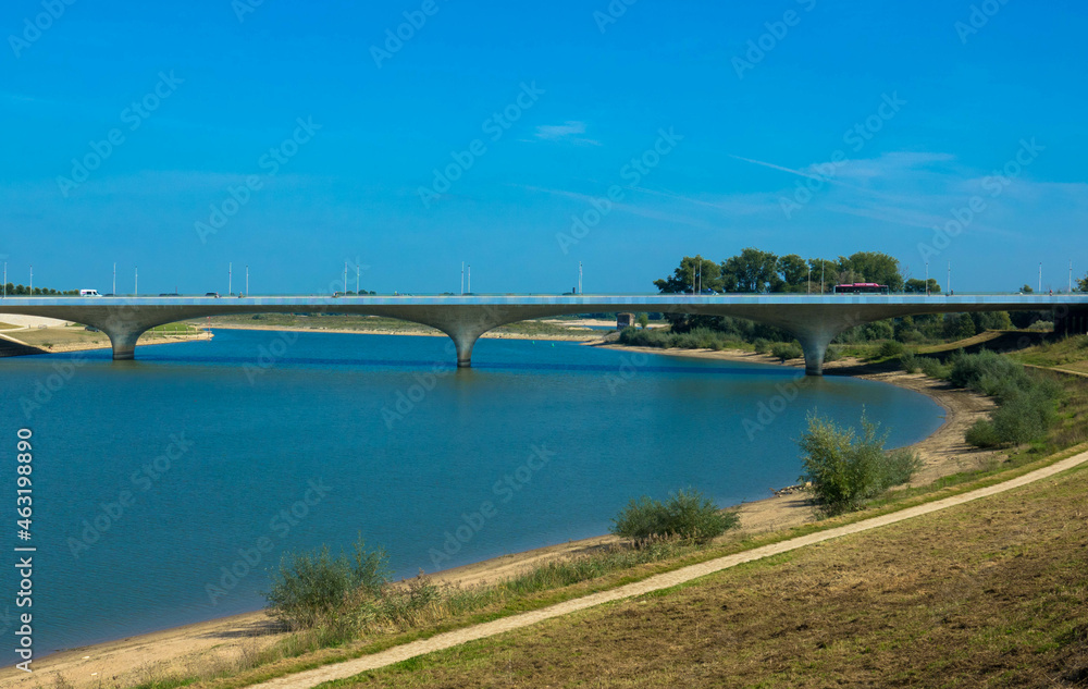 The new Lentloper bridge across the new channel of the river Waal with in the background the city of Nijmegen seen from Oosterhoutsedijk. Gelderland Province, Netherlands The new Lentloper bridge across the new channel of the river Waal with in the background the city of Nijmegen seen from Oosterhoutsedijk. Gelderland Province, Netherlands
