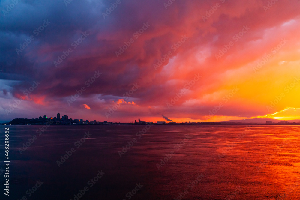 Sunset from the sea bay with red-orange-blue sky. Colorful sky at sunset Sea bay in the Canadian city of Quebec at a picturesque sunset.
