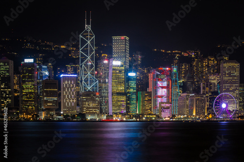 Hong Kong City skyline with tourist sailboat at night. View from across Victoria Harbor HongKong.