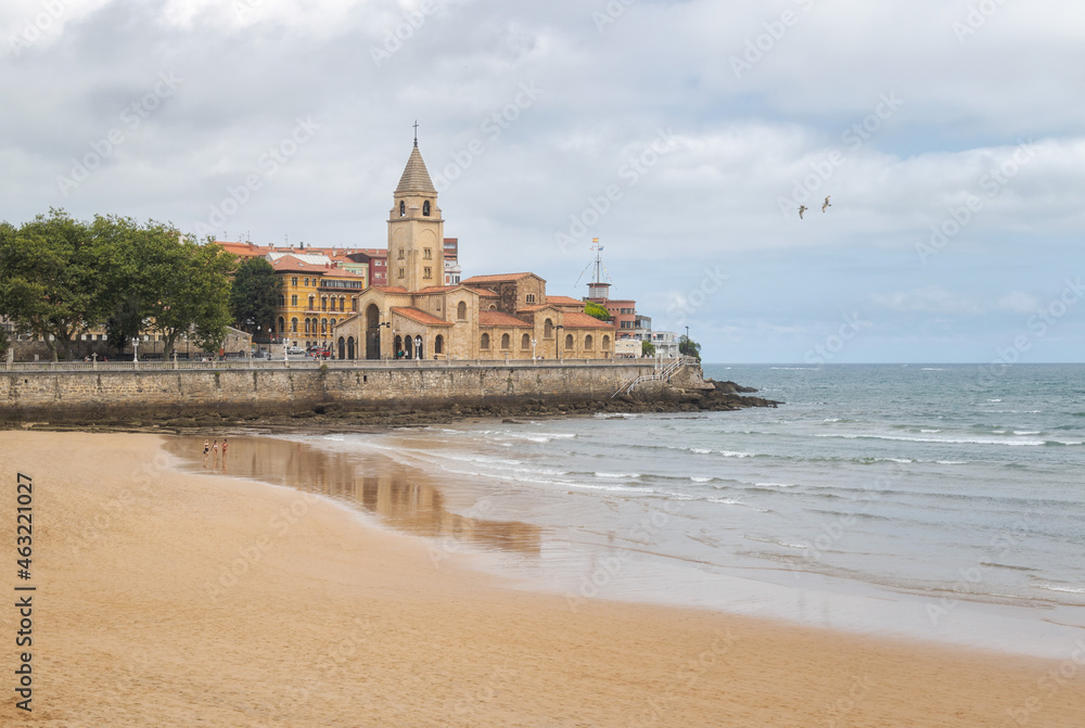 Walk along the beach of San Lorenzo next to the church of San Pedro in Gijón, Asturias, Spain.