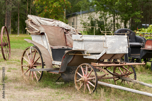 Old carriage in a rural courtyard on a summer day