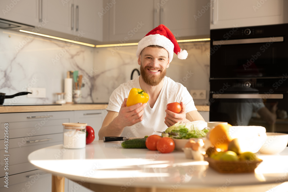 Man holding tomato and pepper at table on kitchen Man holding tomato and pepper at table on kitchen