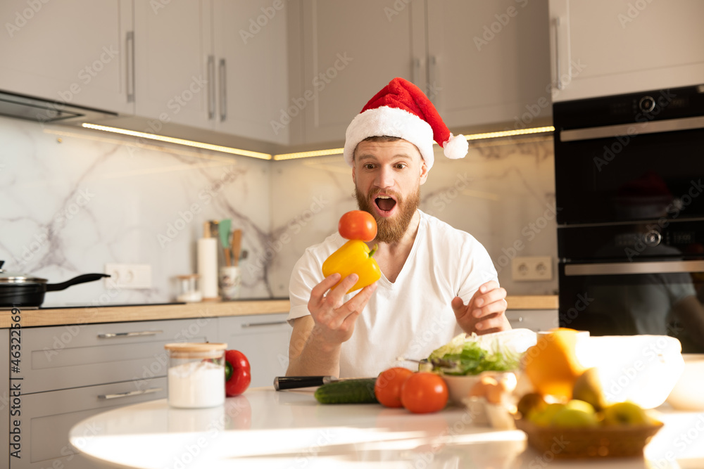 Man holding tomato on pepper at table on kitchen Man holding tomato on pepper at table on kitchen