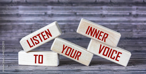 Listen to your inner voice - the text is written on wooden blocks that lie on a wooden background. photo