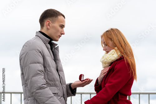 young man makes a marriage proposal to a girl, presents a ring photo