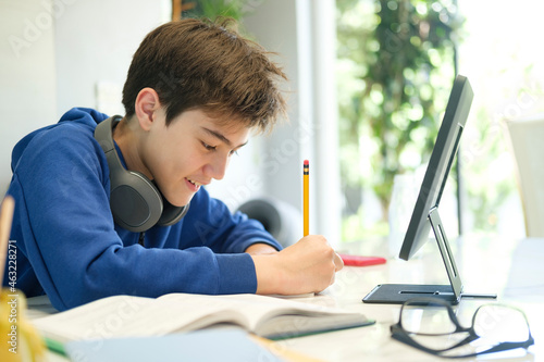 Student boy with tablet computer learning at home. photo