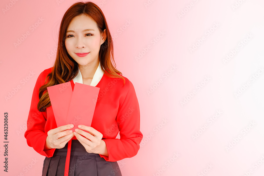 Portrait beautiful asian woman wearing red hanbok dress korea style on pink background with red envelopes holding in hand, celebrate chinese new year concept Portrait beautiful asian woman wearing red hanbok dress korea style on pink background with red envelopes holding in hand, celebrate chinese new year concept