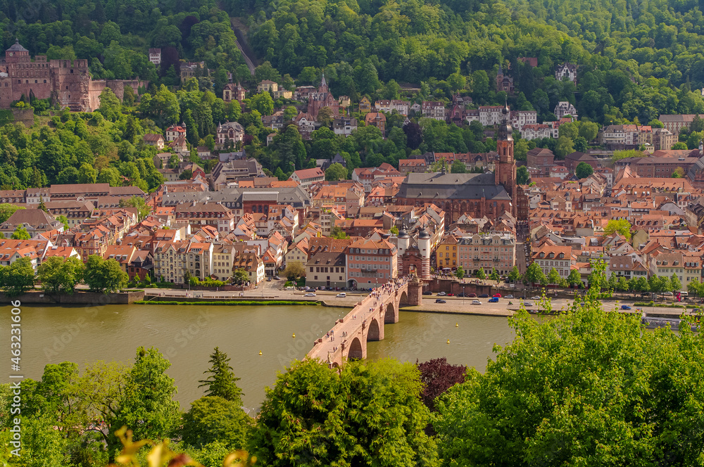 Bird view over old historical downtown, Neckar river, city old bridge and forests at hills in Heidelberg at sunny summer day.