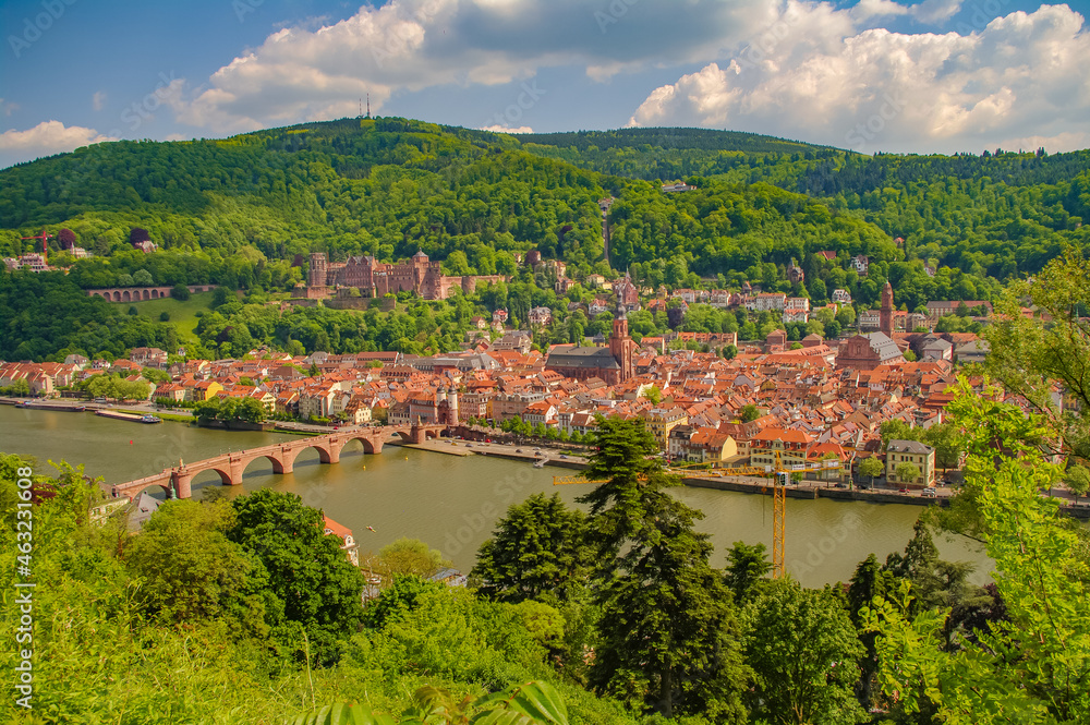 Bird view over old historical downtown, Neckar river, city old bridge and forests at hills in Heidelberg at sunny summer day.