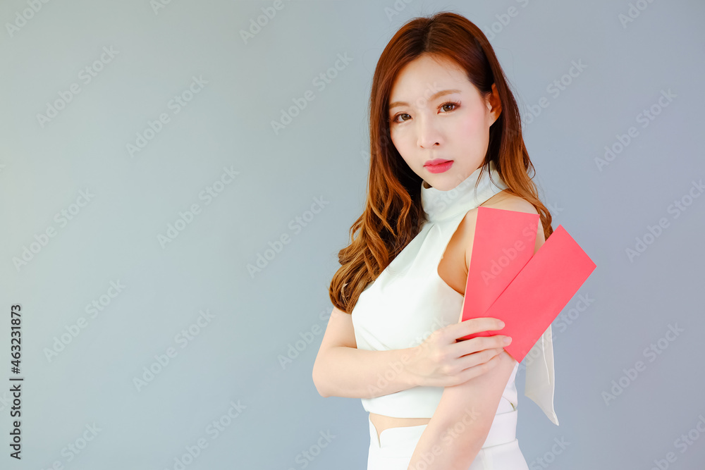 Portrait beautiful asian woman on gray background, with red envelopes holding in hand, celebrate chinese new year concept Portrait beautiful asian woman on gray background, with red envelopes holding in hand, celebrate chinese new year concept