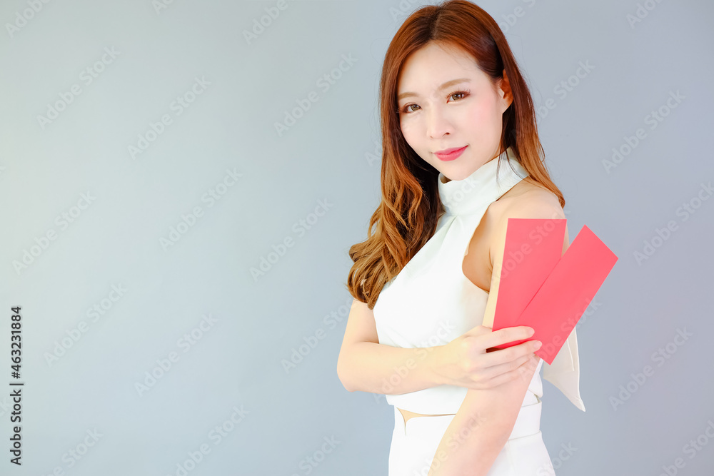 Portrait beautiful asian woman on gray background, with red envelopes holding in hand, celebrate chinese new year concept Portrait beautiful asian woman on gray background, with red envelopes holding in hand, celebrate chinese new year concept