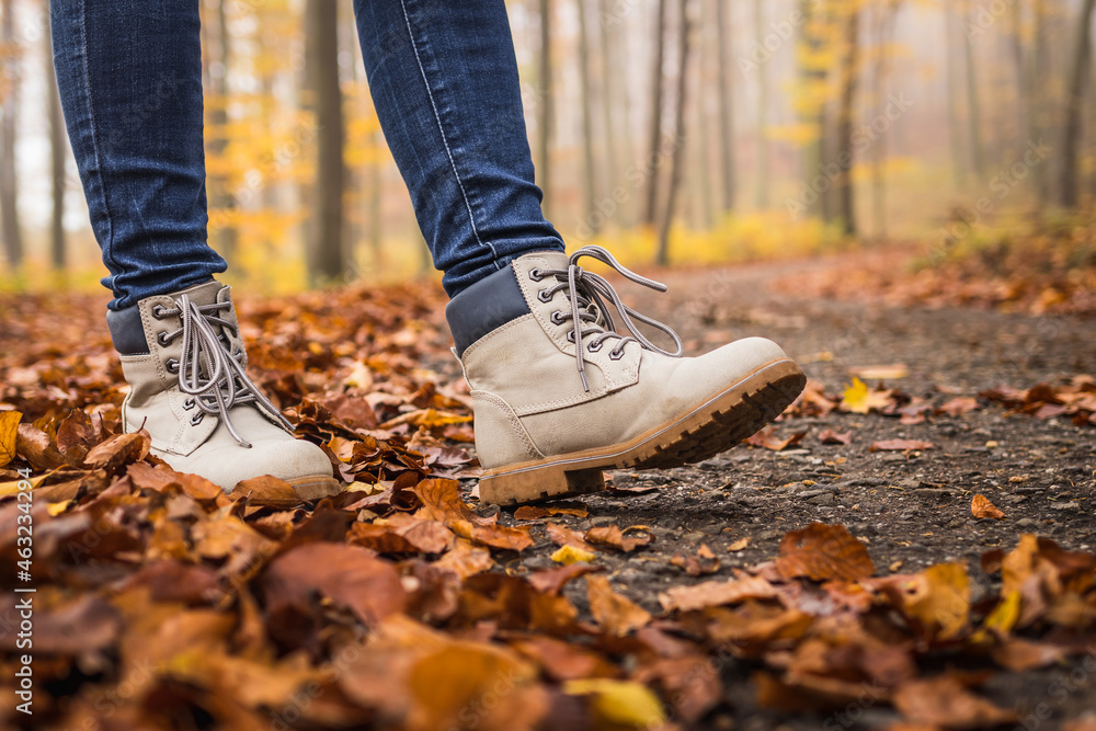 Walk with hiking boots on road at autumn forest Walk with hiking boots on road at autumn forest