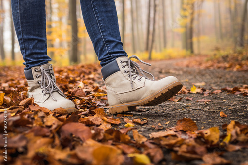 Walk with hiking boots on road at autumn forest
