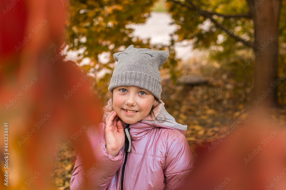 Autumn portrait of a little cute girl. A cheerful child is in the autumn park. Autumn portrait of a little cute girl. A cheerful child is in the autumn park.