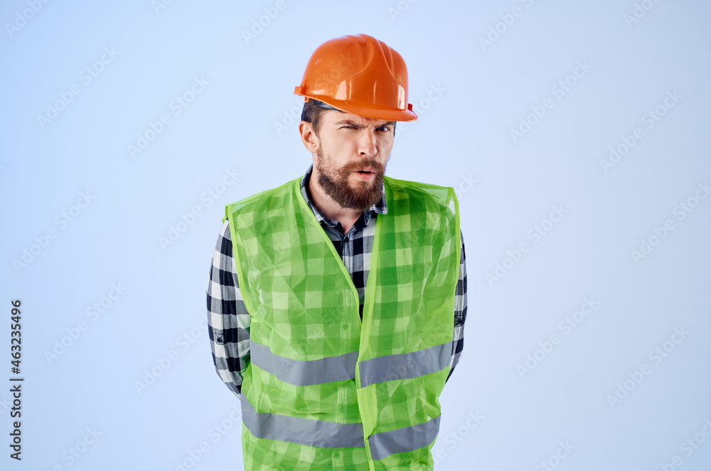 working man in orange hard hat construction professional blue background