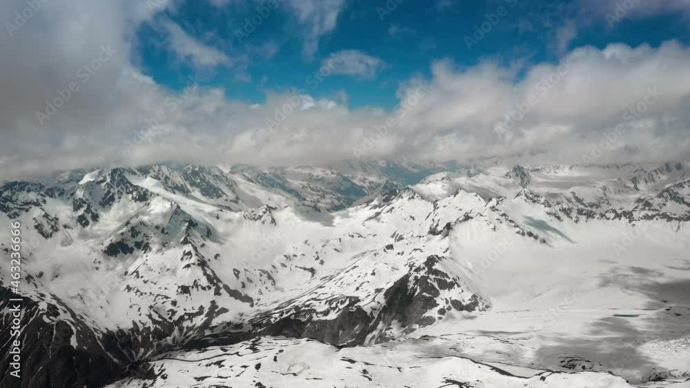 Air flight through mountain clouds over beautiful snow-capped peaks of mountains and glaciers. Air flight through mountain clouds over beautiful snow-capped peaks of mountains and glaciers.
