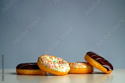 Delicious, fresh donuts multicolored and with chocolate lie next to each other
