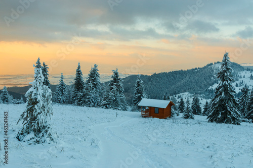 Wooden cottage in a mountain winter landscape. © alpinetrail