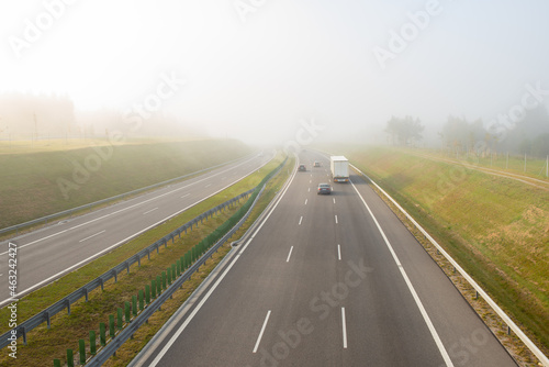 Cars on the highway on a foggy morning.