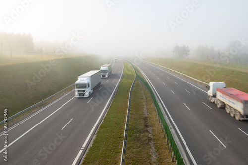 Trucks on the highway on a foggy morning. © JackUli
