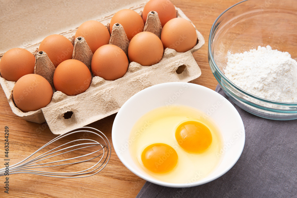 eggs in box and flour on the wooden table eggs in box and flour on the wooden table