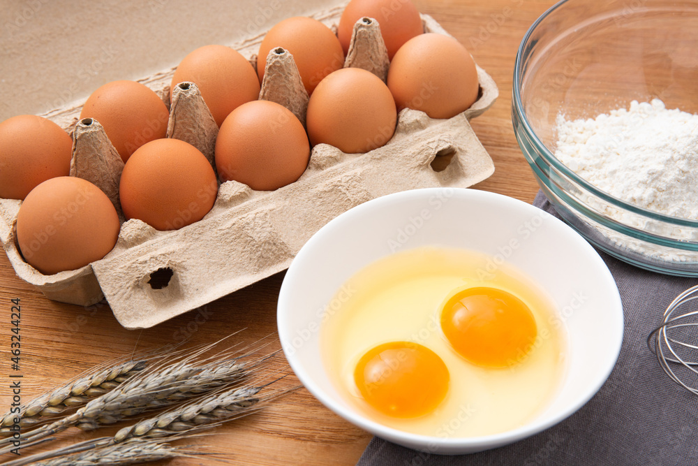 eggs in box and flour on the wooden table eggs in box and flour on the wooden table