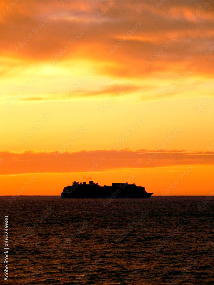 Silhouette of a cruise ship on the horizon at sunset. No people. Copy space.
