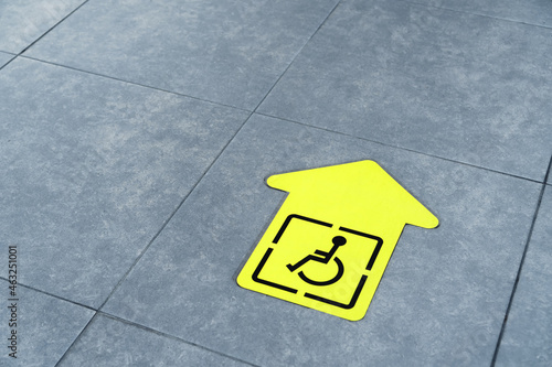 Yellow arrow for the disabled on the floor of the waiting room