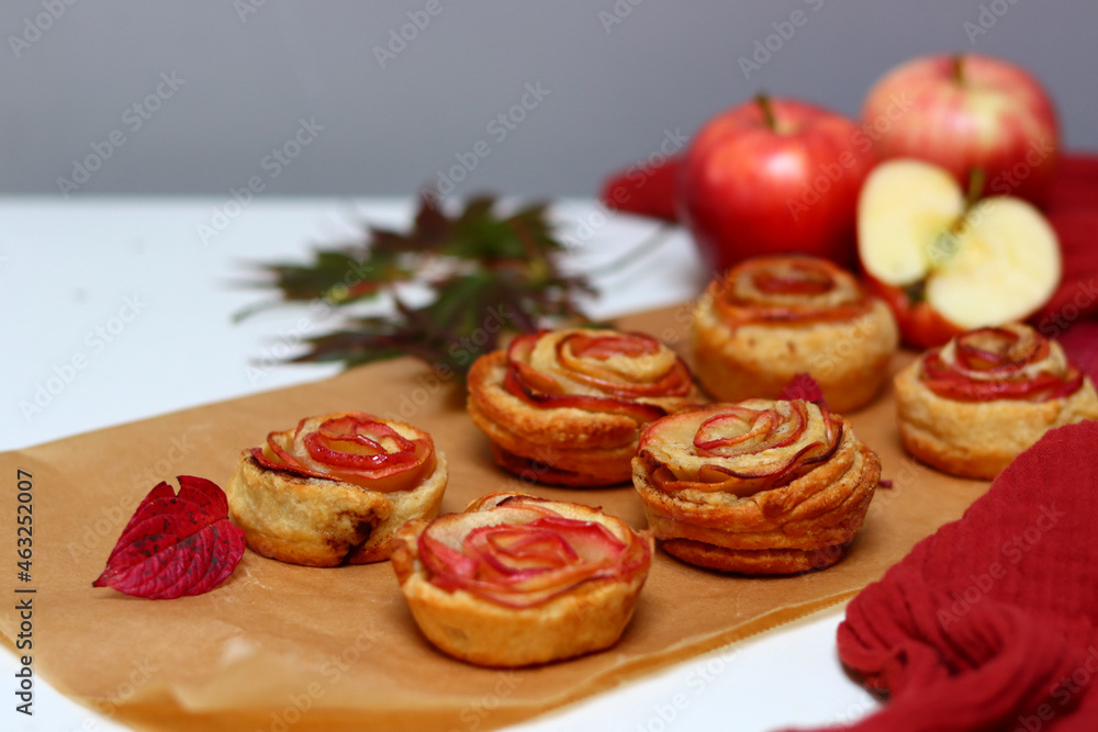 Small apple cupcakes top view photo. Rose shaped tarts with red apples, honey and cinnamon. Autumn food ideas. Small apple cupcakes top view photo. Rose shaped tarts with red apples, honey and cinnamon. Autumn food ideas.