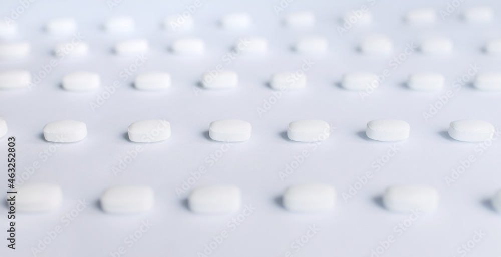 Many white pills on a white background. Health. Many white pills on a white background. Health.