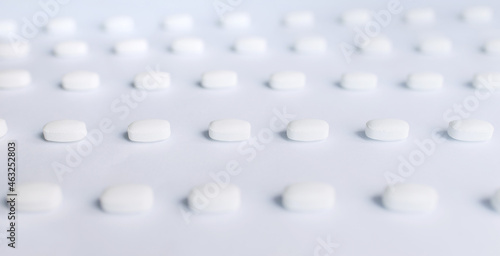 Many white pills on a white background. Health.