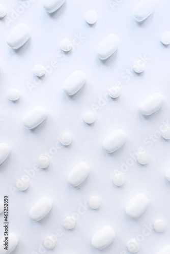 Many white pills on a white background. Health.