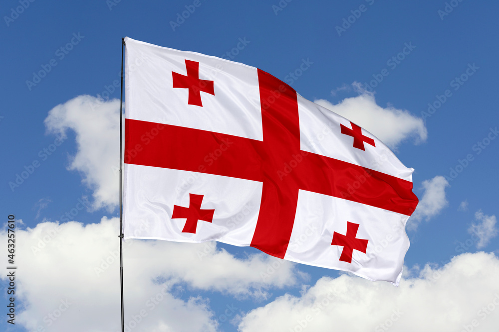 Georgia flag isolated on the blue sky background. close up waving flag of Georgia. flag symbols of Georgia. Concept of Georgia.