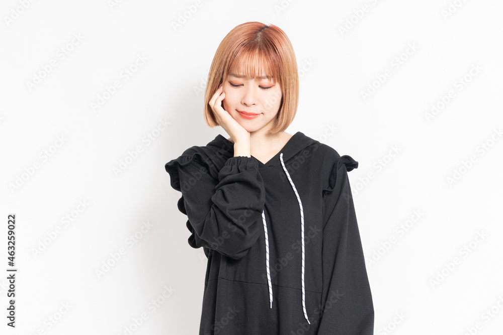 歯が痛くて頬に手を当てるカジュアルな服装の若い女性