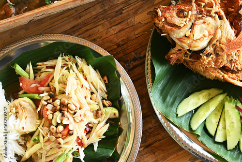 Fotografía Spicy green papaya salad with variety of fresh vegetables and fried fish for lunch time