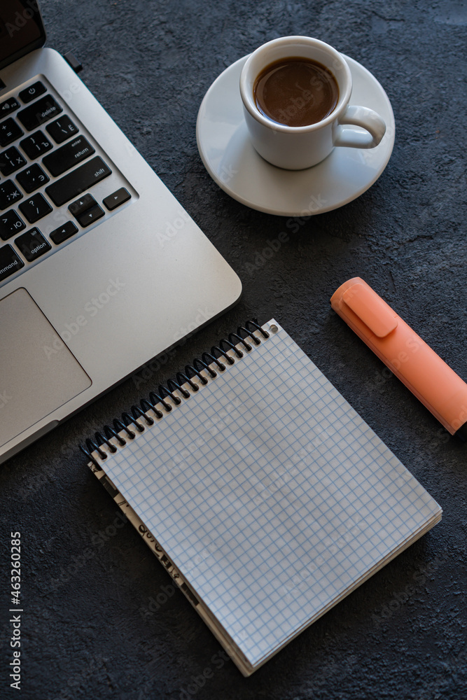 there is a laptop on the table, a mug of coffee and a notebook next to it there is a laptop on the table, a mug of coffee and a notebook next to it