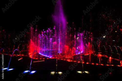 Red-pink jets of the fountain at night.