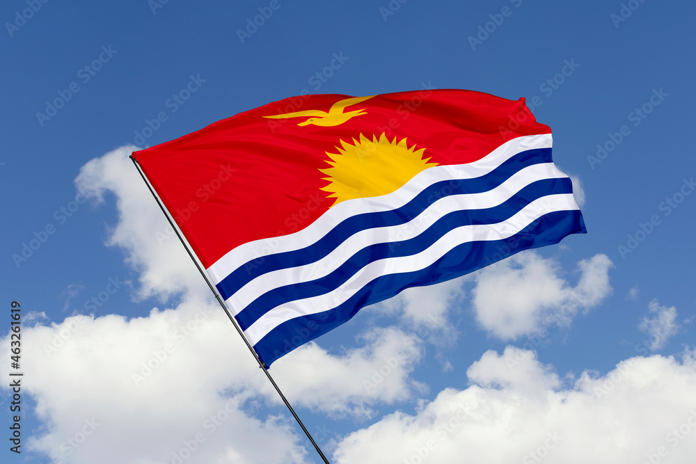 Kiribati flag isolated on the blue sky background. close up waving flag of Kiribati. flag symbols of Kiribati. Concept of Kiribati.