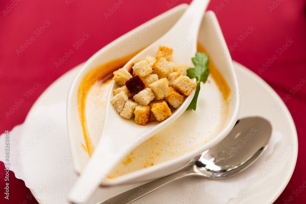 A delicious looking tomato soup plate with cream and croutons on top A delicious looking tomato soup plate with cream and croutons on top