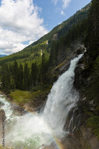 Shot of a waterfall with water falling from a high point and creating rainbow, Krimml Waterfalls Austria
